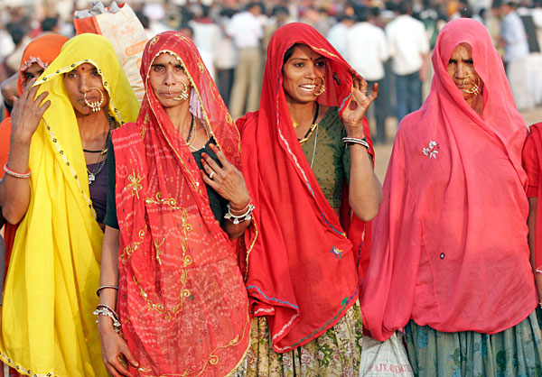 Tout le monde se met sur son 31. Remarquez celle qui remet son sari, un pretexte pour montrer sa main ornée de henné.