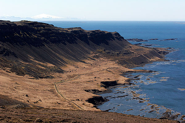 Au loin, le volcan enneigé est le Snæfellsjökull, le volcan qui a servi de decor à Jules Verne pour le Voyage au Centre de la Terre.